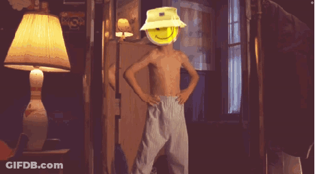 A Shirtless Boy Wearing A Yellow Hat With A Smiley Face On His Head GIF