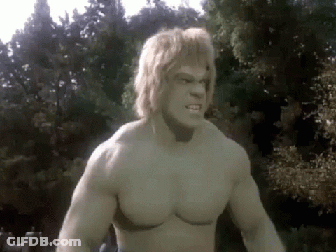 A Shirtless Hulk With Blonde Hair Is Standing In Front Of A Forest . GIF