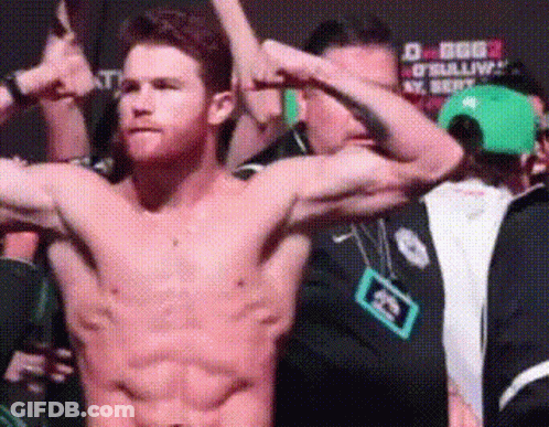 A Shirtless Man Flexes His Muscles In Front Of A Crowd GIF