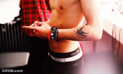 A Shirtless Man Has A Tattoo Of A Bird On His Arm GIF
