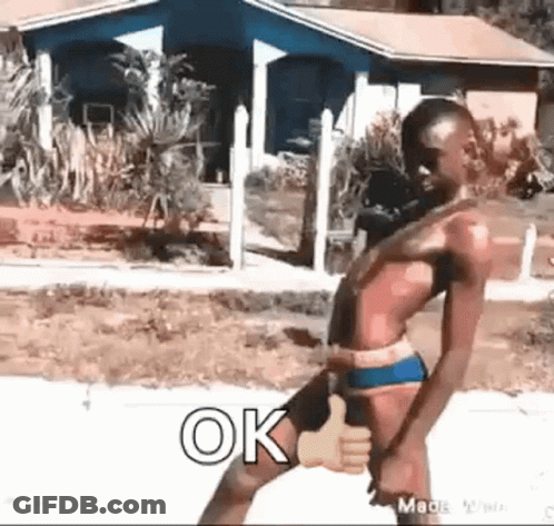 A Shirtless Man In A Bathing Suit Is Giving A Thumbs Up Sign . GIF