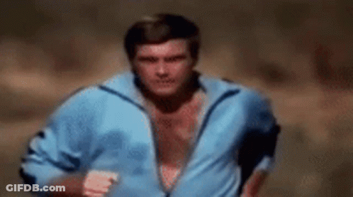 A Shirtless Man In A Blue Jacket Is Running . GIF