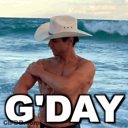 A Shirtless Man In A Cowboy Hat Stands On The Beach With The Words G'day Below Him GIF