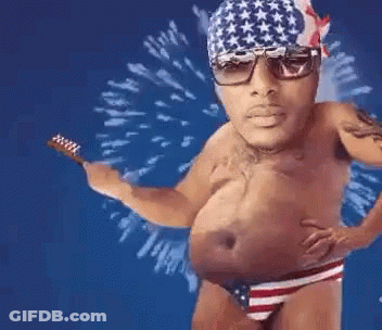 A Shirtless Man In An American Flag Underwear Is Holding A Toothbrush In His Hand . GIF