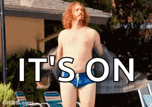 A Shirtless Man In Blue Swim Trunks Is Standing In Front Of A Pool With The Words " It 'S On " Above Him . GIF