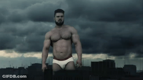 A Shirtless Man In Calvin Klein Underwear Stands In Front Of A City GIF