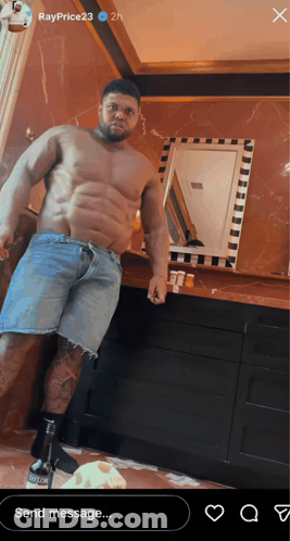 A Shirtless Man In Denim Shorts Is Standing In Front Of A Mirror In A Bathroom GIF