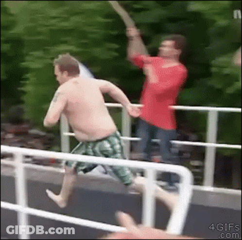 A Shirtless Man In Green Shorts Is Jumping Off A Bridge GIF