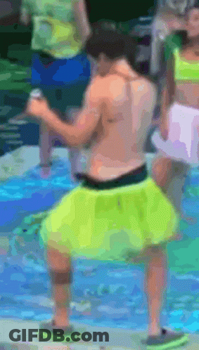 A Shirtless Man In Neon Yellow Shorts Is Dancing In The Water GIF