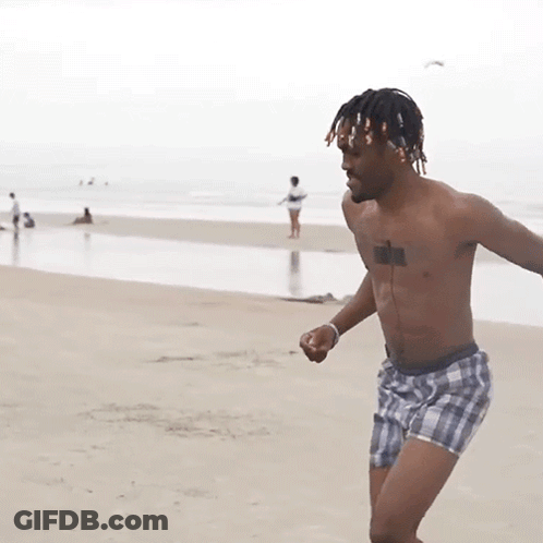 A Shirtless Man In Plaid Shorts Has A Tattoo On His Chest GIF