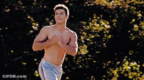 A Shirtless Man In Shorts Is Running In A Park GIF