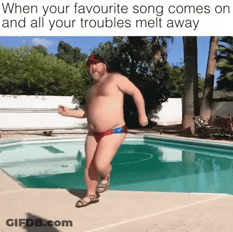 A Shirtless Man In Swim Trunks Is Dancing In Front Of A Pool . GIF