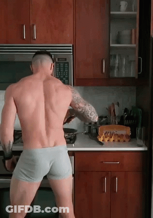 A Shirtless Man In Underwear Is Standing In A Kitchen Cooking GIF