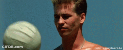 A Shirtless Man Is Balancing A Volleyball On His Fingertips . GIF