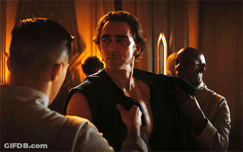 A Shirtless Man Is Being Helped By Another Man GIF