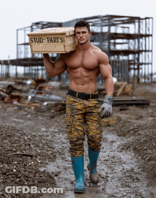 A Shirtless Man Is Carrying A Box Of Stud Parts GIF