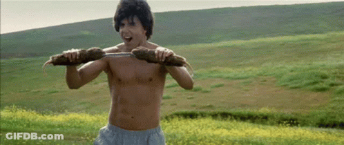 A Shirtless Man Is Carrying A Large Piece Of Wood On His Shoulders . GIF