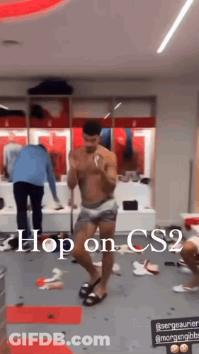 A Shirtless Man Is Dancing In A Locker Room With The Words `` Hop On Cs2 '' Written Above Him . GIF