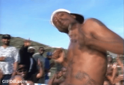 A Shirtless Man Is Dancing In Front Of A Crowd Of People GIF