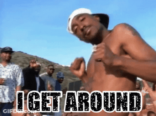 A Shirtless Man Is Dancing In Front Of A Crowd With The Words I Get Around Above Him GIF