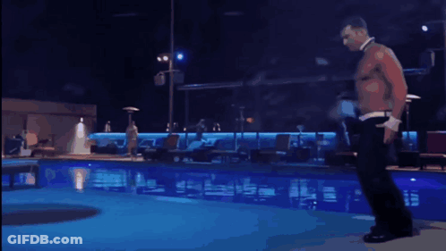 A Shirtless Man Is Dancing In Front Of A Pool GIF