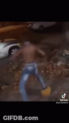A Shirtless Man Is Dancing In Front Of A Silver Car GIF