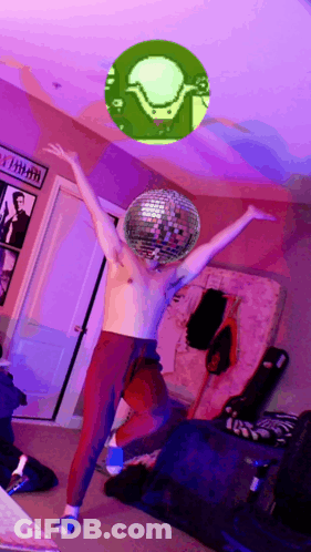 A Shirtless Man Is Dancing With A Disco Ball In Front Of His Head GIF