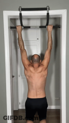 A Shirtless Man Is Doing Pull Ups On A Bar In A Doorway GIF