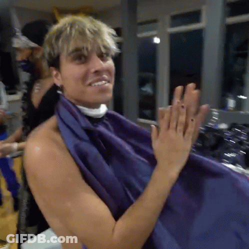 A Shirtless Man Is Getting His Hair Cut With A Purple Cloth GIF