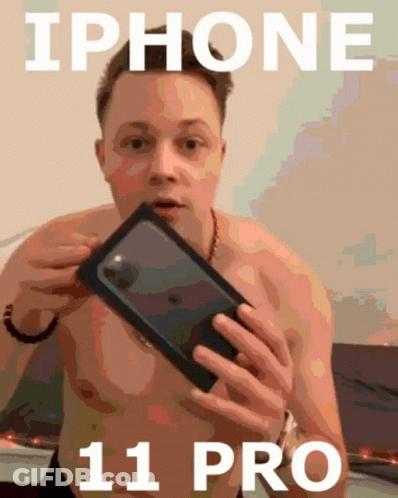A Shirtless Man Is Holding A Black Iphone 11 Pro GIF