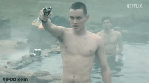 A Shirtless Man Is Holding A Gun While Standing In A Pool Of Water . GIF