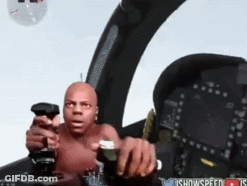 A Shirtless Man Is Holding A Joystick In A Cockpit With A Twitter Icon In The Corner GIF