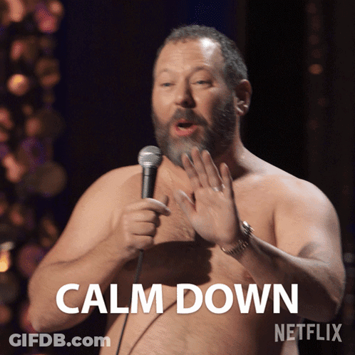 A Shirtless Man Is Holding A Microphone And Says Calm Down On The Screen GIF