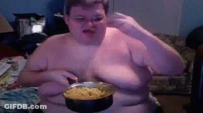 A Shirtless Man Is Holding A Pot Of Food In Front Of His Face GIF
