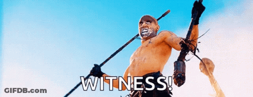 A Shirtless Man Is Holding A Spear And The Word Witness Is On The Bottom Right GIF
