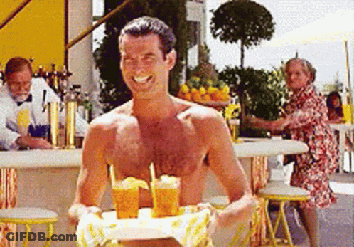 A Shirtless Man Is Holding A Tray Of Drinks GIF