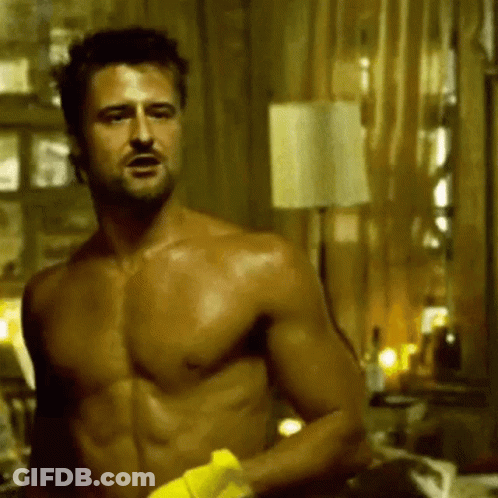 A Shirtless Man Is Holding A Yellow Towel In A Room . GIF
