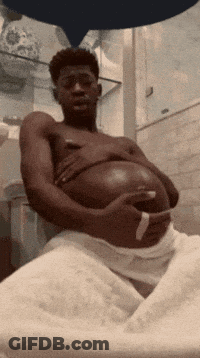 A Shirtless Man Is Holding His Pregnant Belly GIF