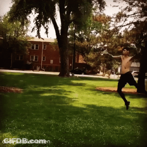 A Shirtless Man Is Jumping In The Air In A Park With The Words Andys-Stolen-Omen Written Below Him GIF