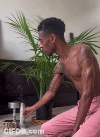 A Shirtless Man Is Kneeling Down In Front Of A Potted Plant With The Name Kalvinkosha On The Bottom Right GIF