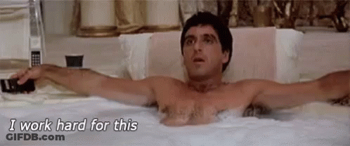 A Shirtless Man Is Laying In A Bathtub With His Arms Outstretched And Says `` I Work Hard For This '' . GIF