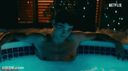 A Shirtless Man Is Laying In A Hot Tub With A Netflix Logo Behind Him GIF