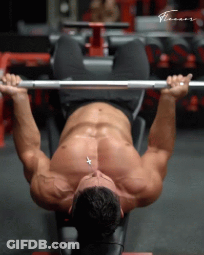 A Shirtless Man Is Lifting A Barbell In A Gym With The Word Fitness Written On The Bottom GIF
