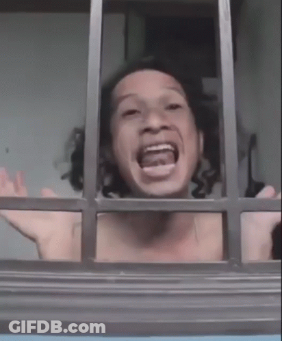 A Shirtless Man Is Looking Out Of A Window With His Mouth Open And His Arms Outstretched . GIF