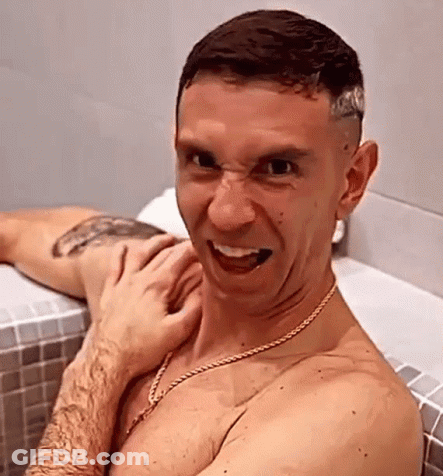 A Shirtless Man Is Making A Funny Face While Taking A Bath . GIF