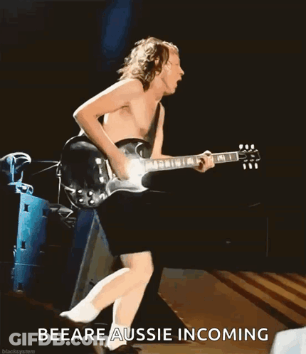 A Shirtless Man Is Playing A Guitar On A Stage With The Words Beeare Aussie Incoming Behind Him GIF