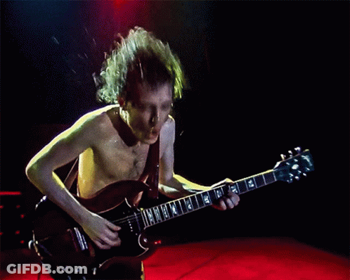 A Shirtless Man Is Playing A Guitar With A Gibson Logo GIF