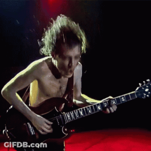A Shirtless Man Is Playing A Guitar With The Letters Nm On It GIF