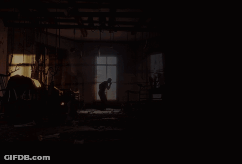 A Shirtless Man Is Riding A White Horse In A Dark Room GIF