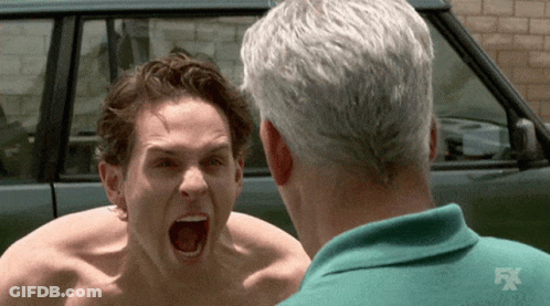 A Shirtless Man Is Screaming At Another Shirtless Man In Front Of A Car That Says Fx GIF